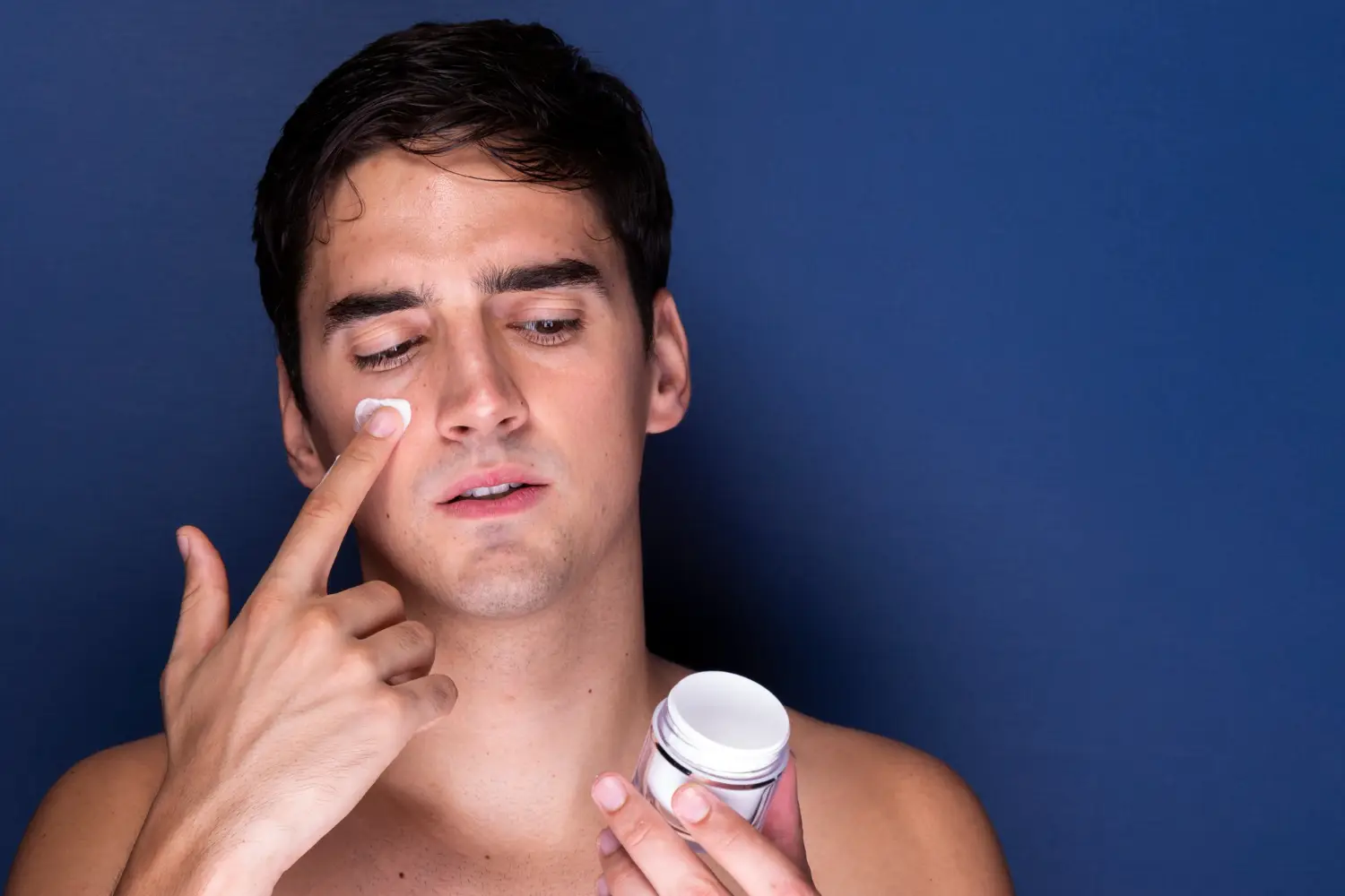Person with oily skin applying moisturizer showing importance of hydration for all skin types