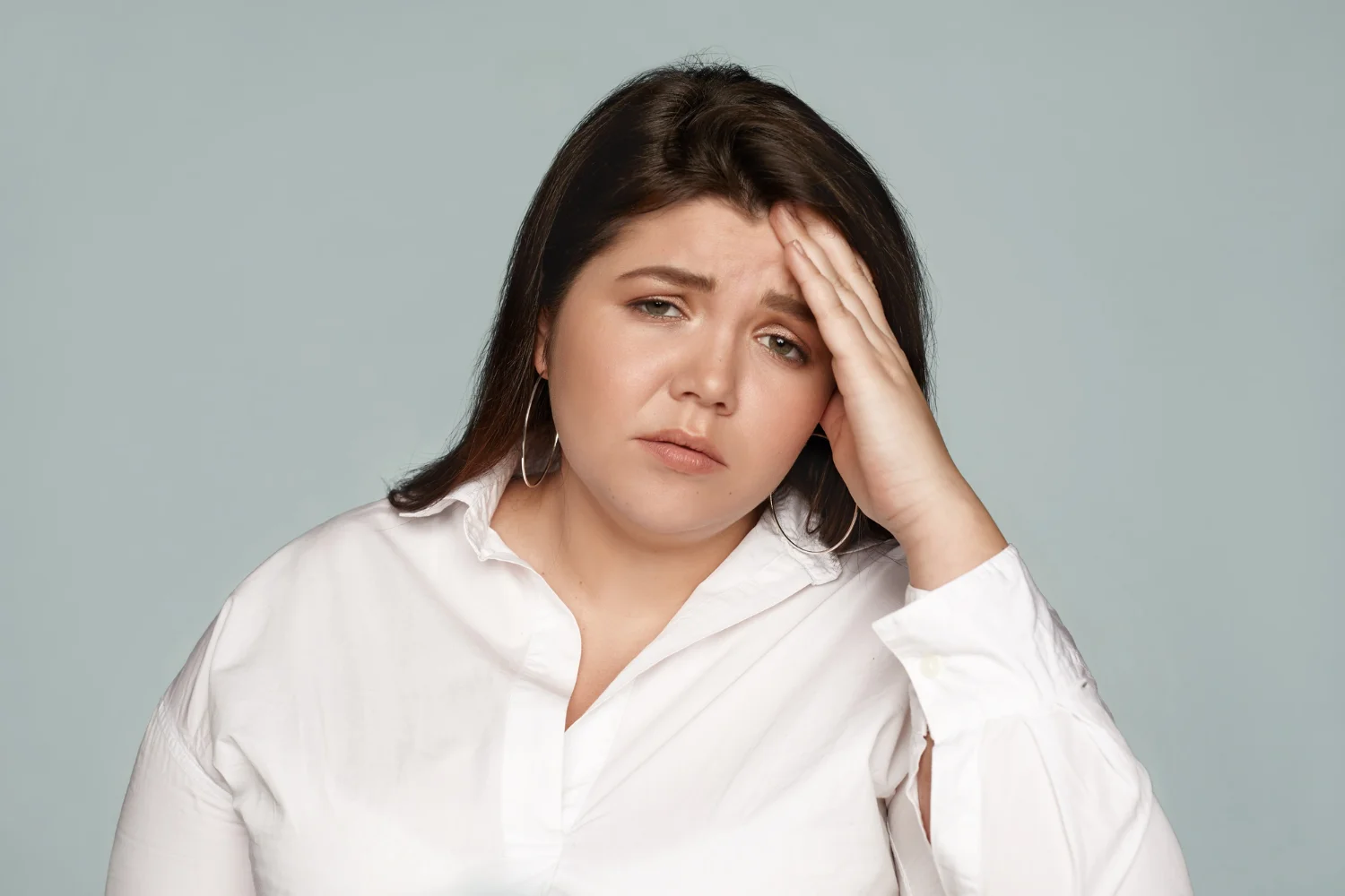 Woman showing common PCOS symptoms including acne, weight gain, and facial hair growth
